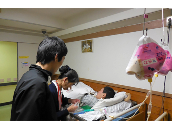 生活棟で医療処置にあたる看護師の写真