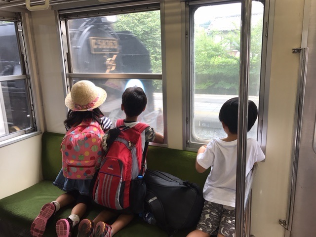 電車からSLを見ている写真