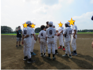 青空の下、ユニフォーム姿の子どもたちの写真
