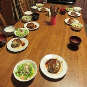 食卓にハンバーグやサラダが並んでいる写真