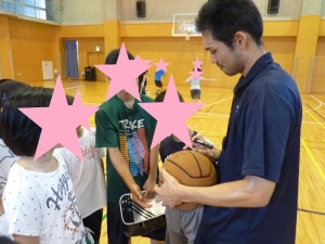 高山選手がボールにサインを書いている写真